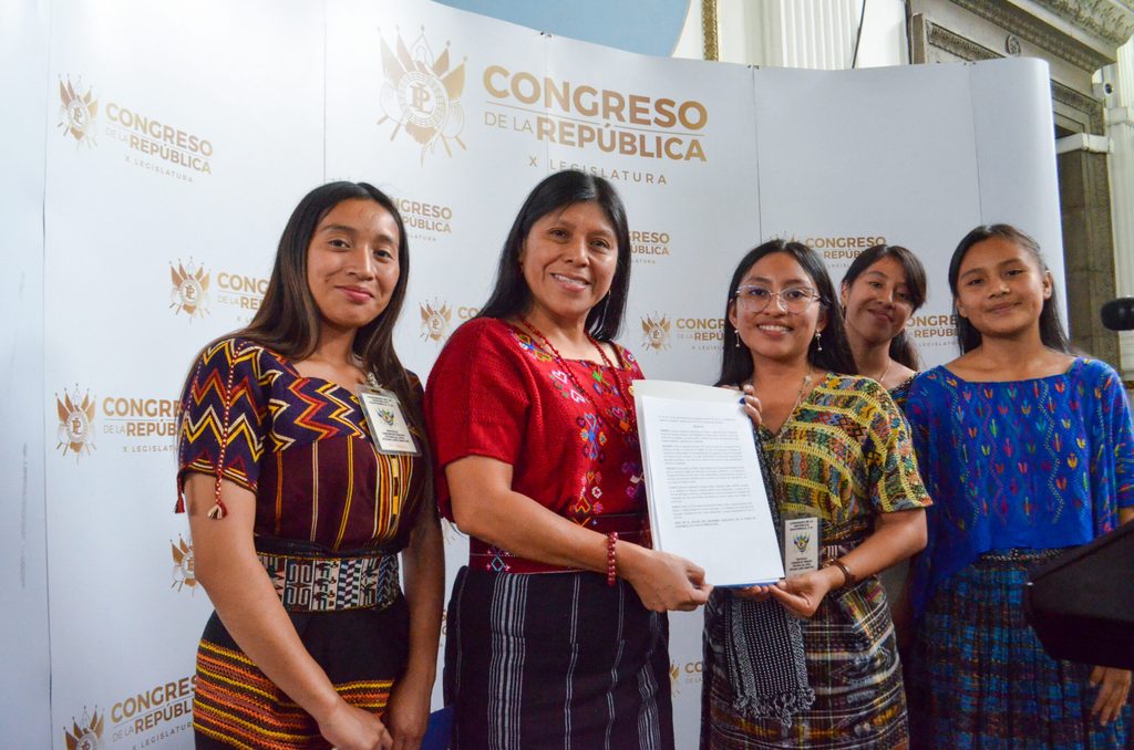 Niñas voceras posan con la diputada presidenta de la Comisión de la Mujer del Congreso de Guatemala.