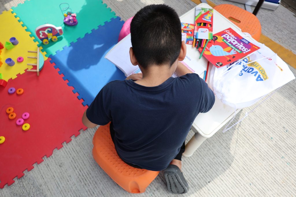 Niño jugando en un espacio lúdico instalado para la atención de personas en situación de movilidad humana.