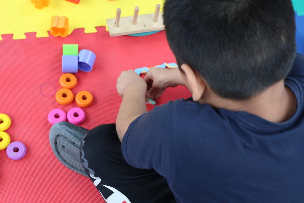 Hijo de Andrea jugando en un espacio lúdico instalado junto a una unidad móvil para la atención de personas en situación de movilidad humana.