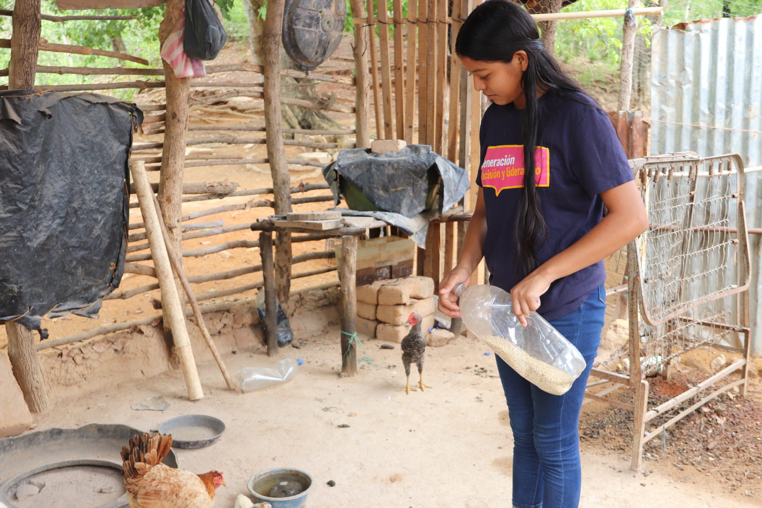 Rixi alimentando a los animales de granja en su casa. Foto: Alejandra Cerrato @Plan International