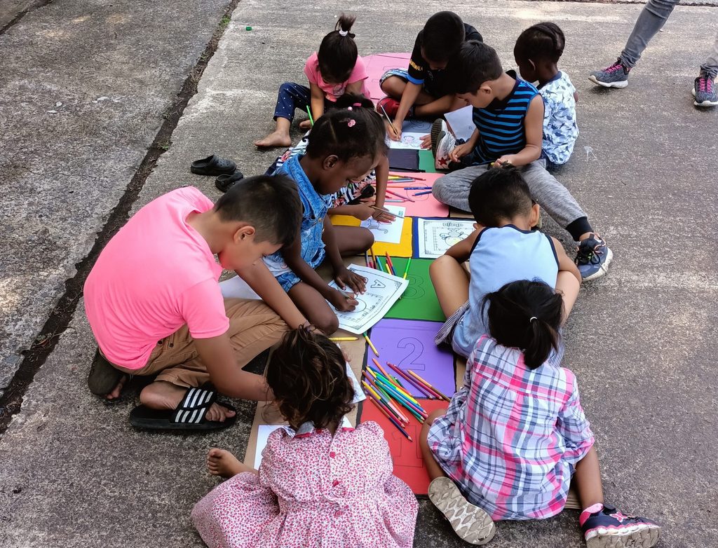 Niñas y niños realizando actividades como parte de talleres con personas en contexto de migración