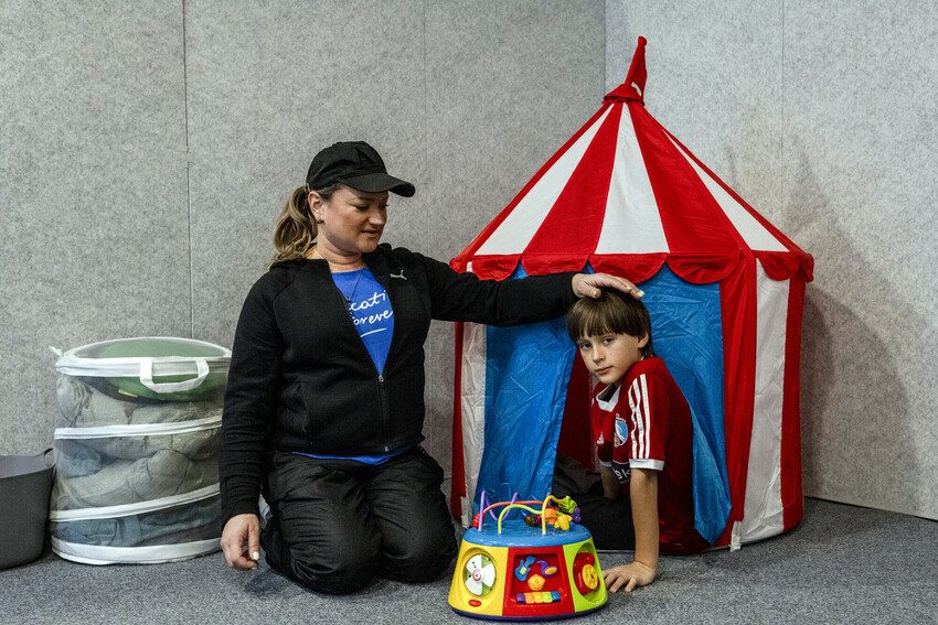 Maryna plays with her 8-year-old son Nikita at the day care centre 