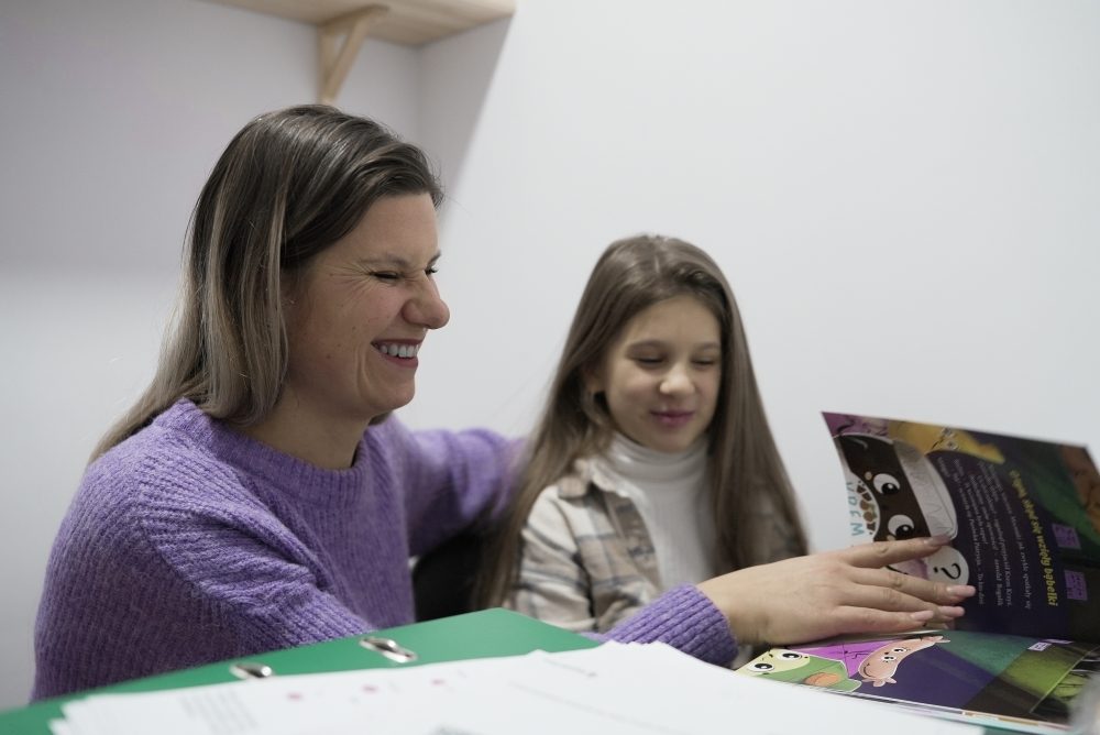 Halyna reading with her eight-year-old daughter in Polish.