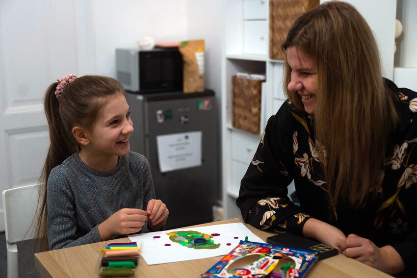 Halyna with her daughter Zlata. Zlata is drawing.