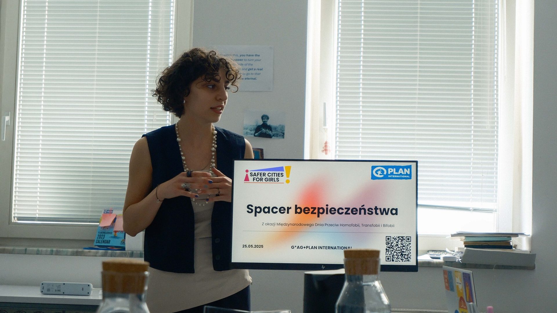 Girl standing next to a screen with a presentation.