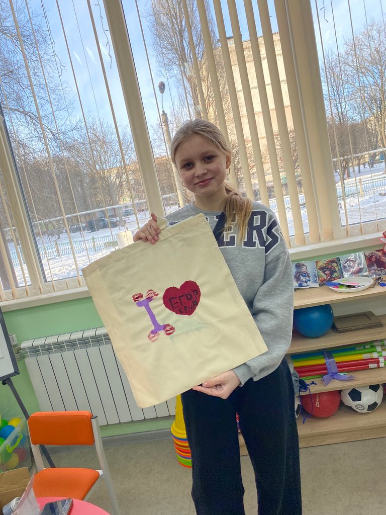 Polina, 12, holds up a picture she has made.