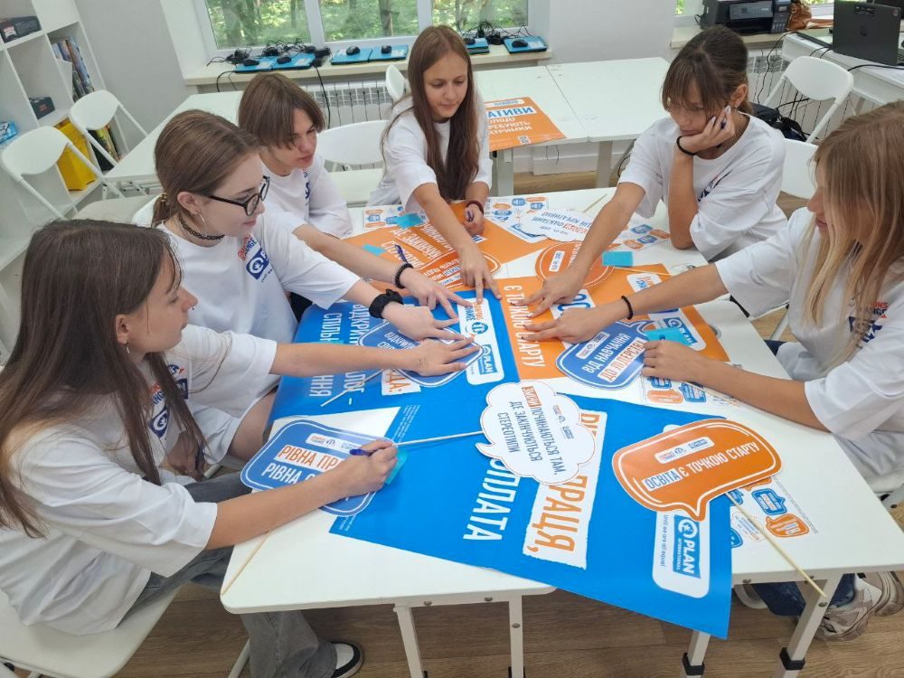 Six adolescents around a table participating in a group activity.